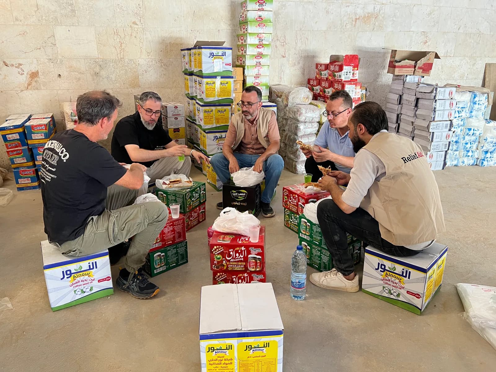 Mike Seawright shares lunch with the ReliefAid team among aid supplies in Syria